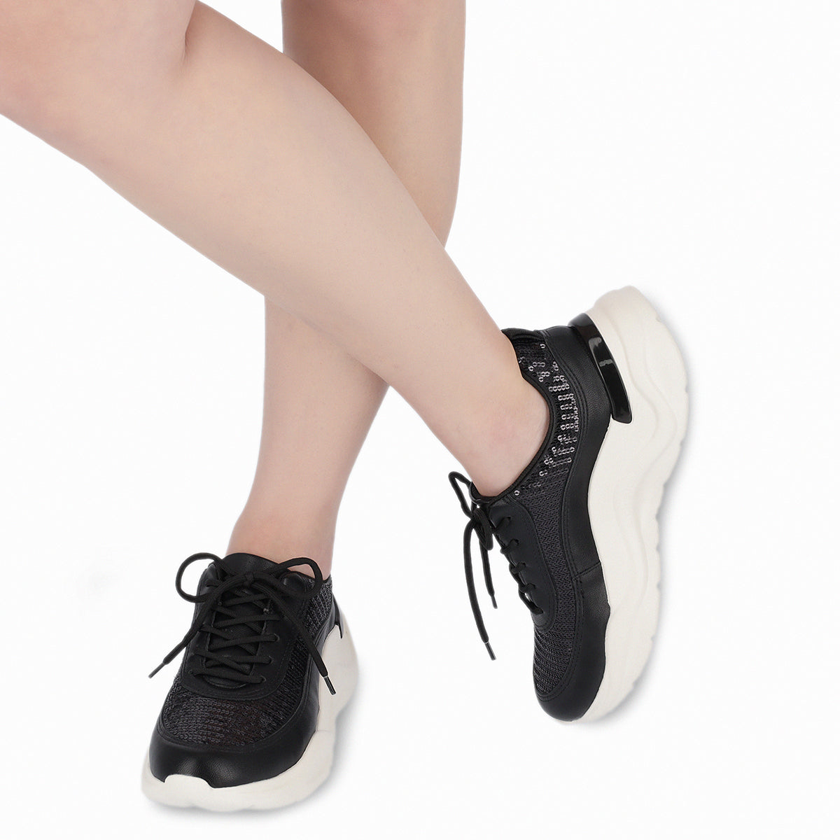 modelo con par de tenis color negro de cuña media con lentejuelas y plantilla anatómica para fascitis plantar para mujer