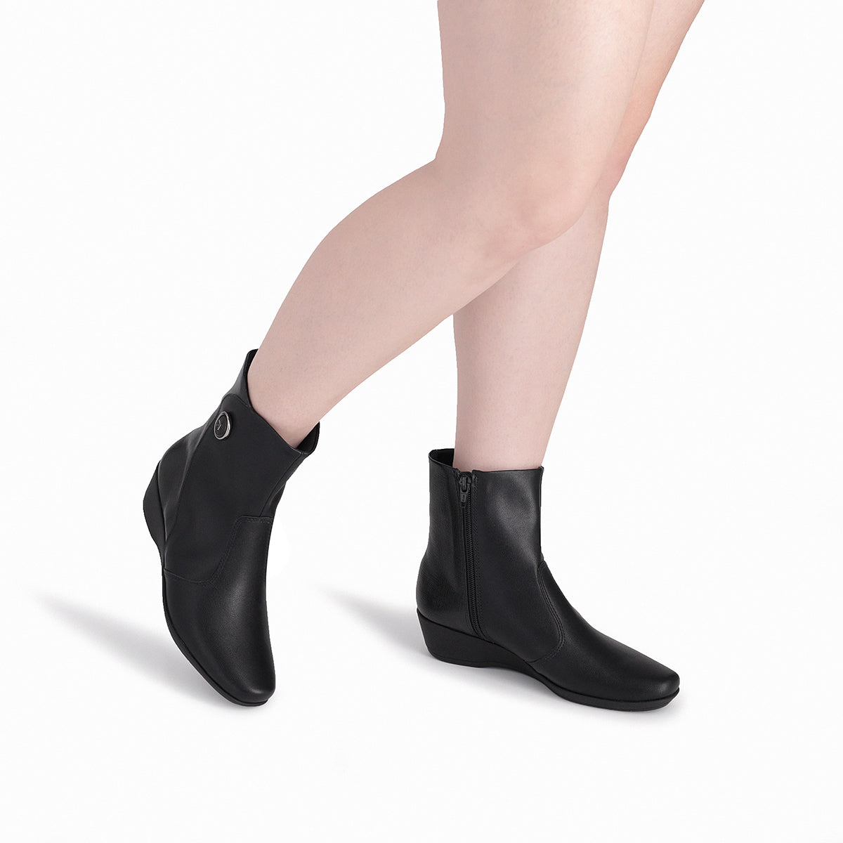 modelo con un par de botines negros tacón bajo corrido 3 cm con cierre, arriba del tobillo para mujer colección Ivone. Cómodo, sostenible y elegante, con suela adherente.