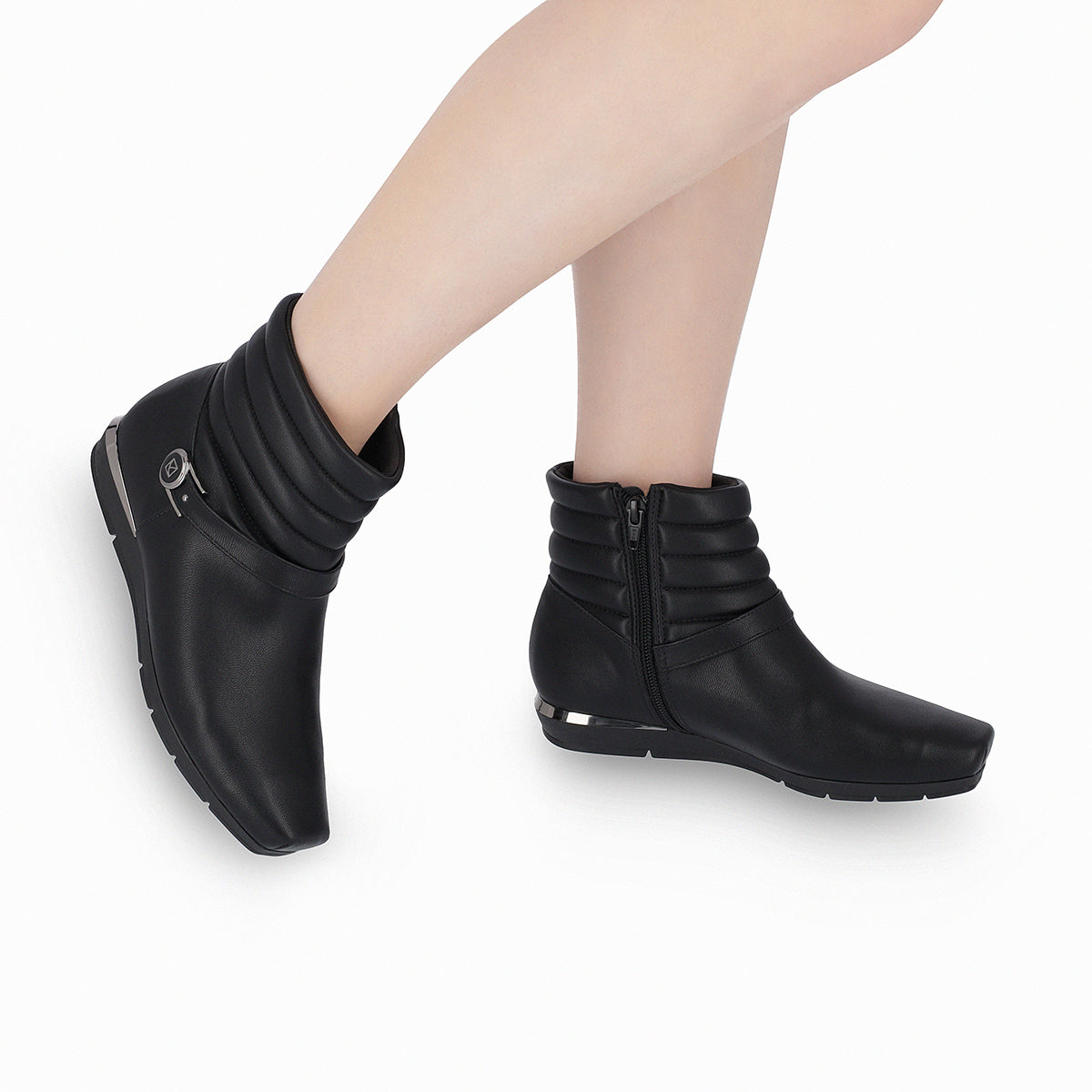 Modelo con botines color negro cuña baja 1 cm decoración de cintillo a la altura del tobillo y detalle plateado en el tacón para mujer colección Raquel. Diseño juvenil y audaz
